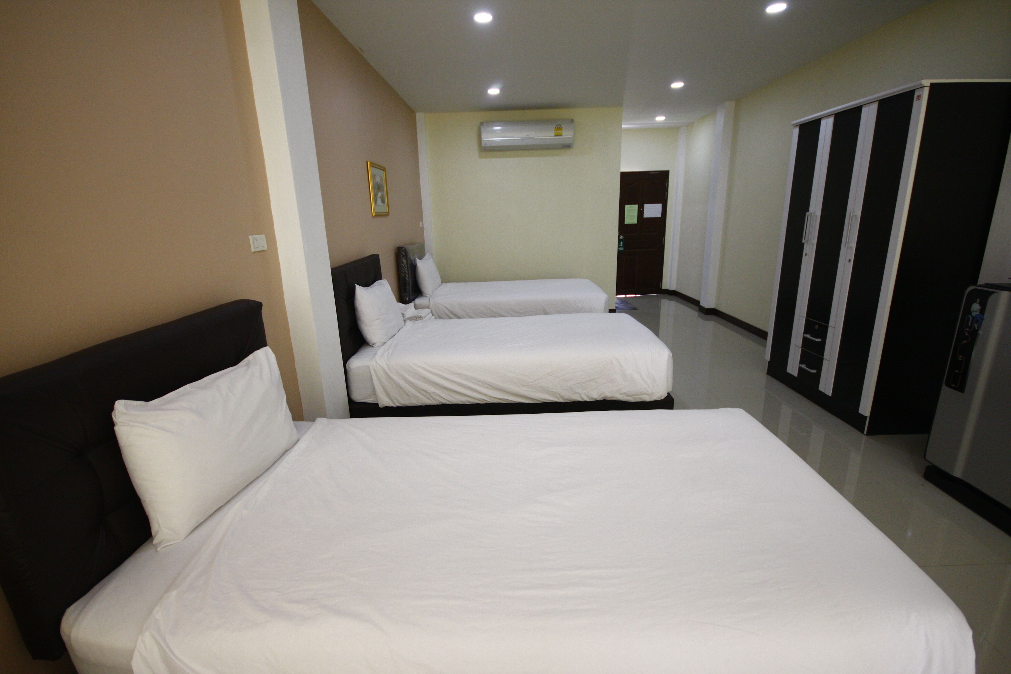 Une chambre d’hôtel avec deux lits, une armoire et un appareil de climatisation.