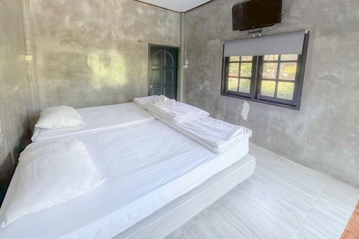A room with a bed, a window, and a door.
