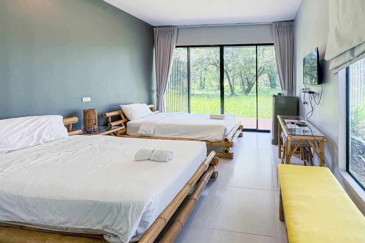 A room with two beds, a TV, and a dining table.