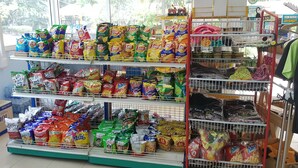 Un pasillo de supermercado con diversos productos y alimentos en las estanterías.