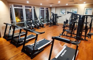 A gym with treadmills, weight machines, and exercise bikes.