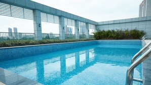 Une piscine intérieure moderne, avec une eau d’un bleu limpide, entourée d’une terrasse carrelée et de rampes en métal.