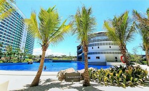 Un resort con piscina, palme e un edificio con un cartello che recita 'The Azure Beach'.