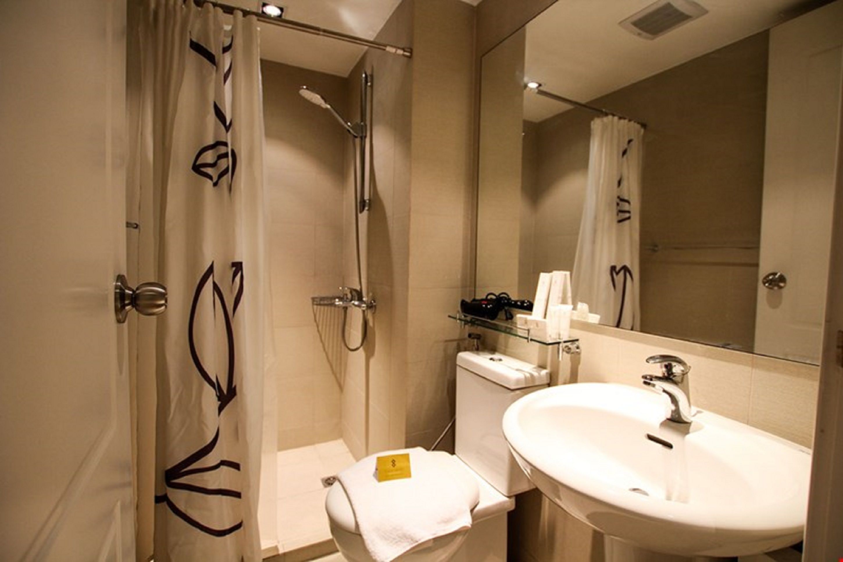 Un baño moderno con ducha, inodoro y lavamanos.