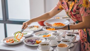 Una mesa de comedor con diversos platos y tazas, probablemente en un restaurante o cafetería.