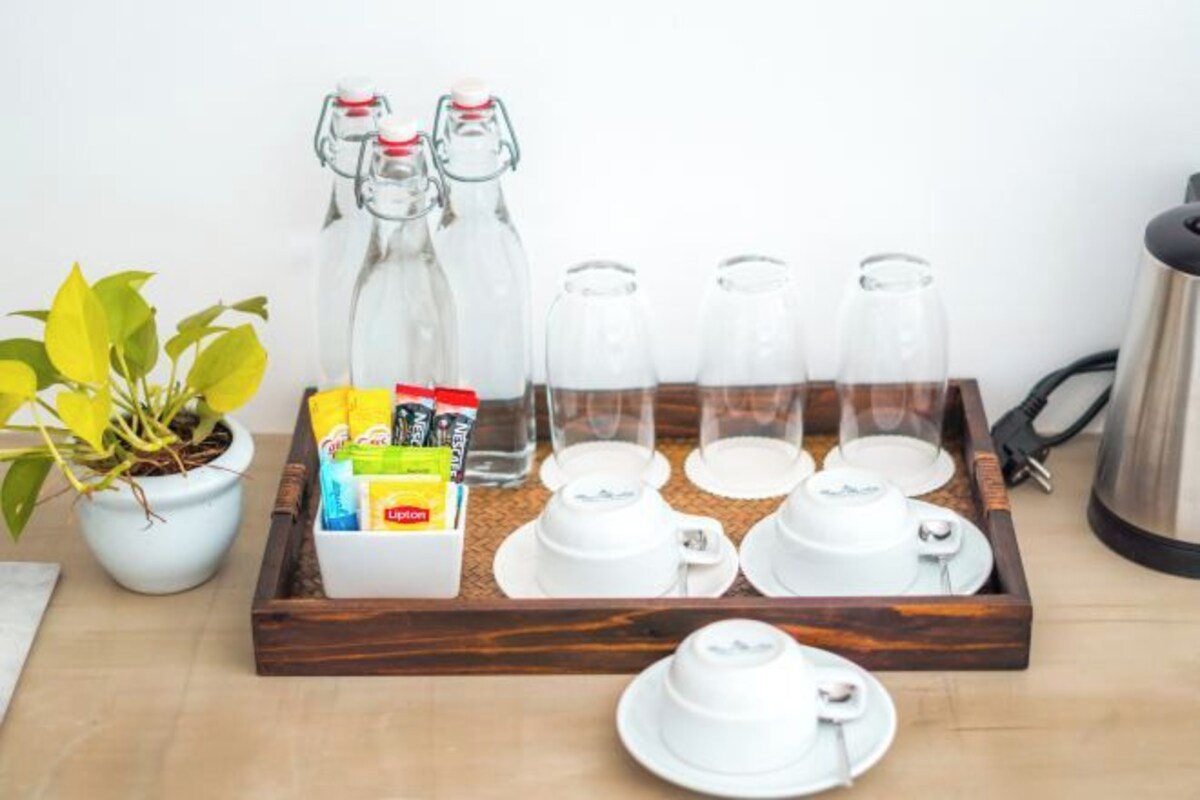 A tray with glass bottles, a plant, and a box of toiletries.