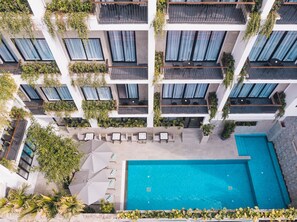 A modern hotel with multiple balconies, a swimming pool, and outdoor seating areas. - Angkor Aurora (Siem Reap)