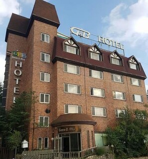 A multi-story brick building with a sign reading "CB Hotel". - Green and Blue Hotel (Pyeongchang)