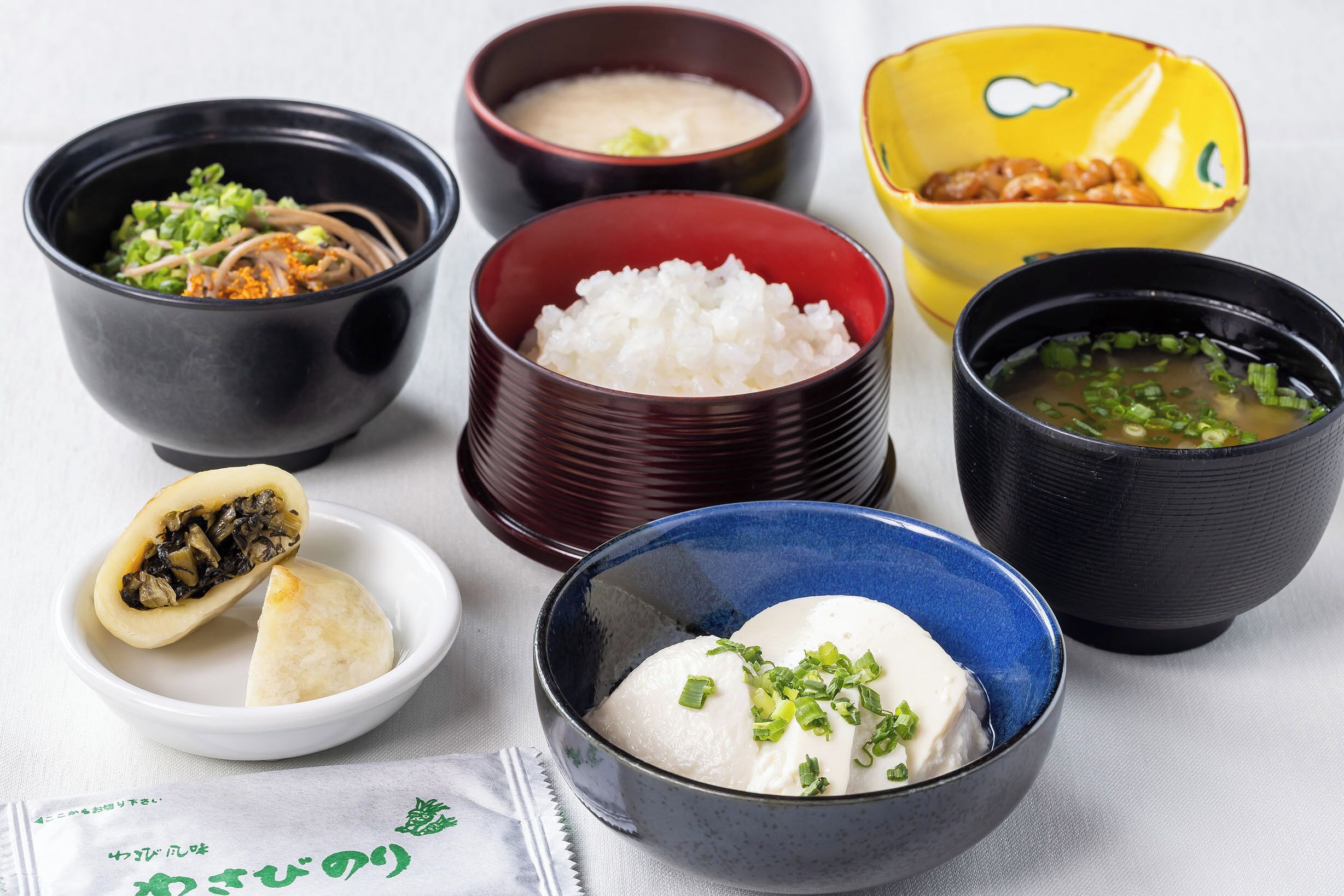 Diversos pratos japoneses, incluindo arroz, sopa e dumplings.