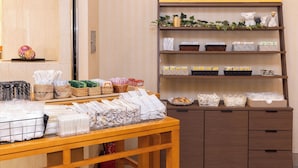 A hotel amenity bar with neatly arranged towels, baskets, and toiletries. - Alpico Plaza Hotel (Matsumoto)