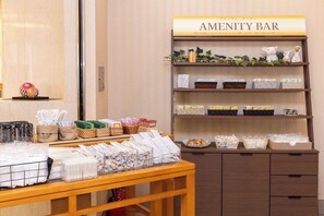 A hotel amenity bar with neatly arranged towels, baskets, and toiletries. - Alpico Plaza Hotel (Matsumoto)