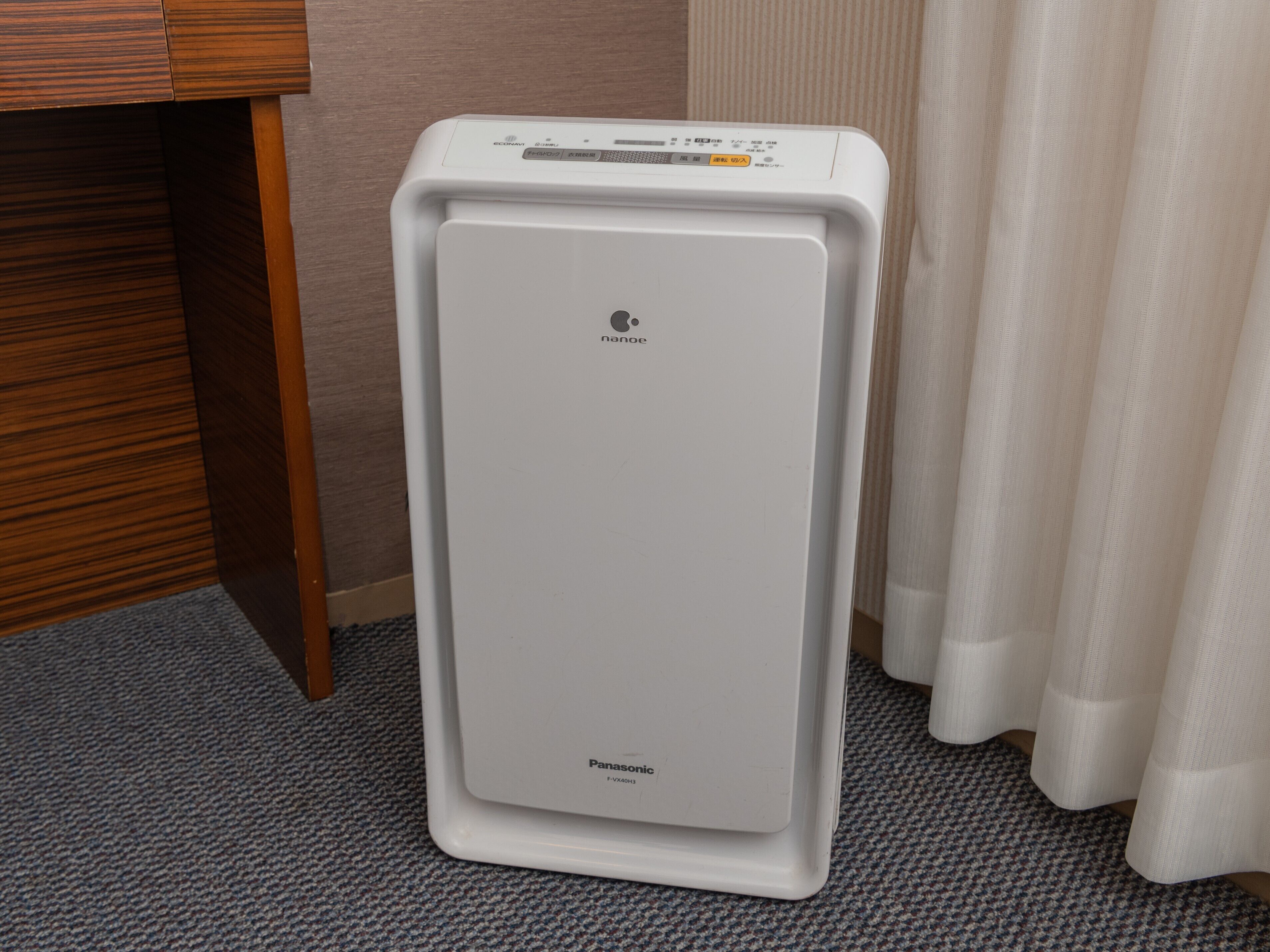 Un refrigerador Panasonic blanco en una habitación de hotel.