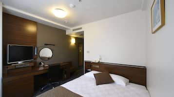 Una habitación de hotel con cama, escritorio, televisor, espejo y teléfono.