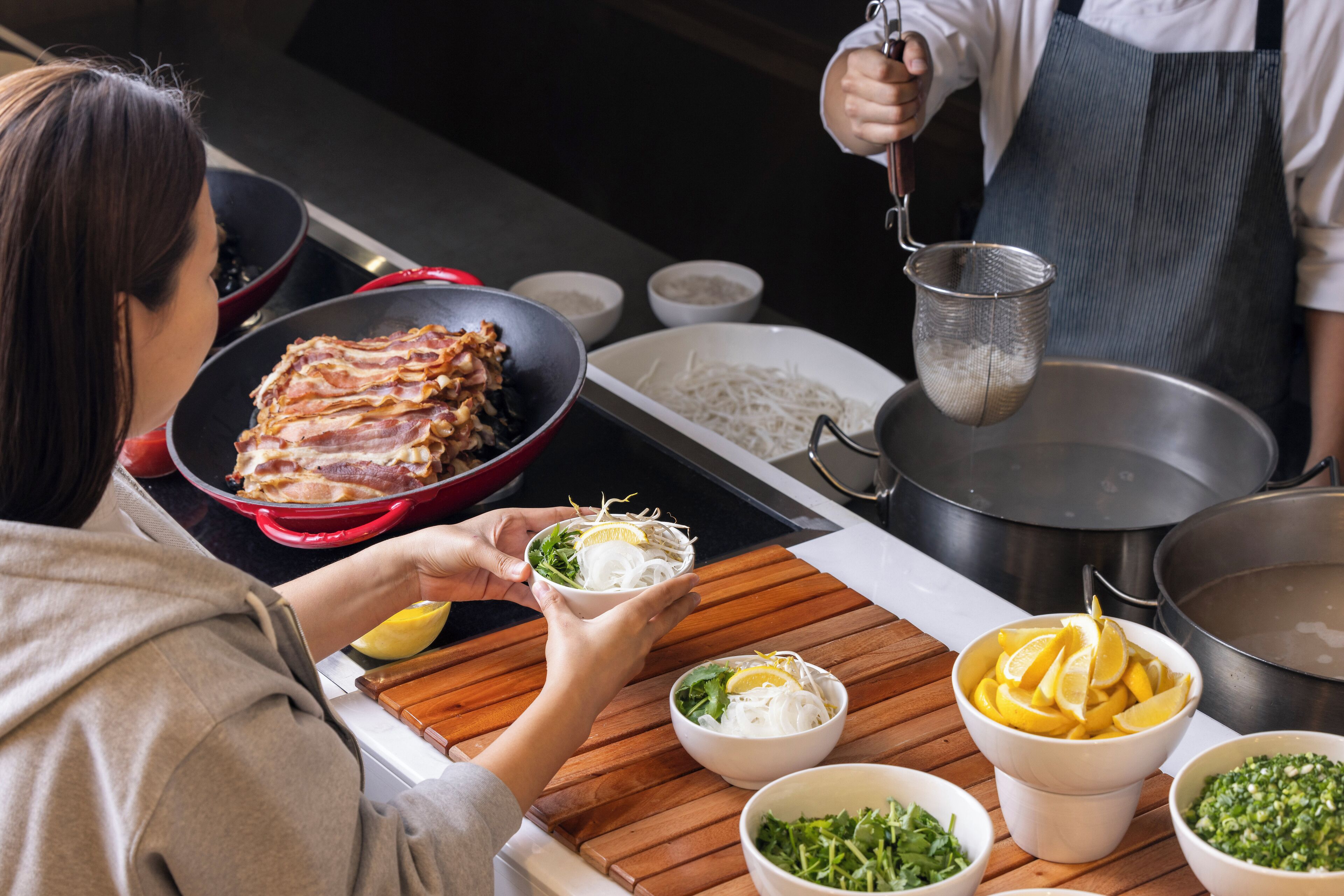 A kitchen counter with various food items and cooking utensils.