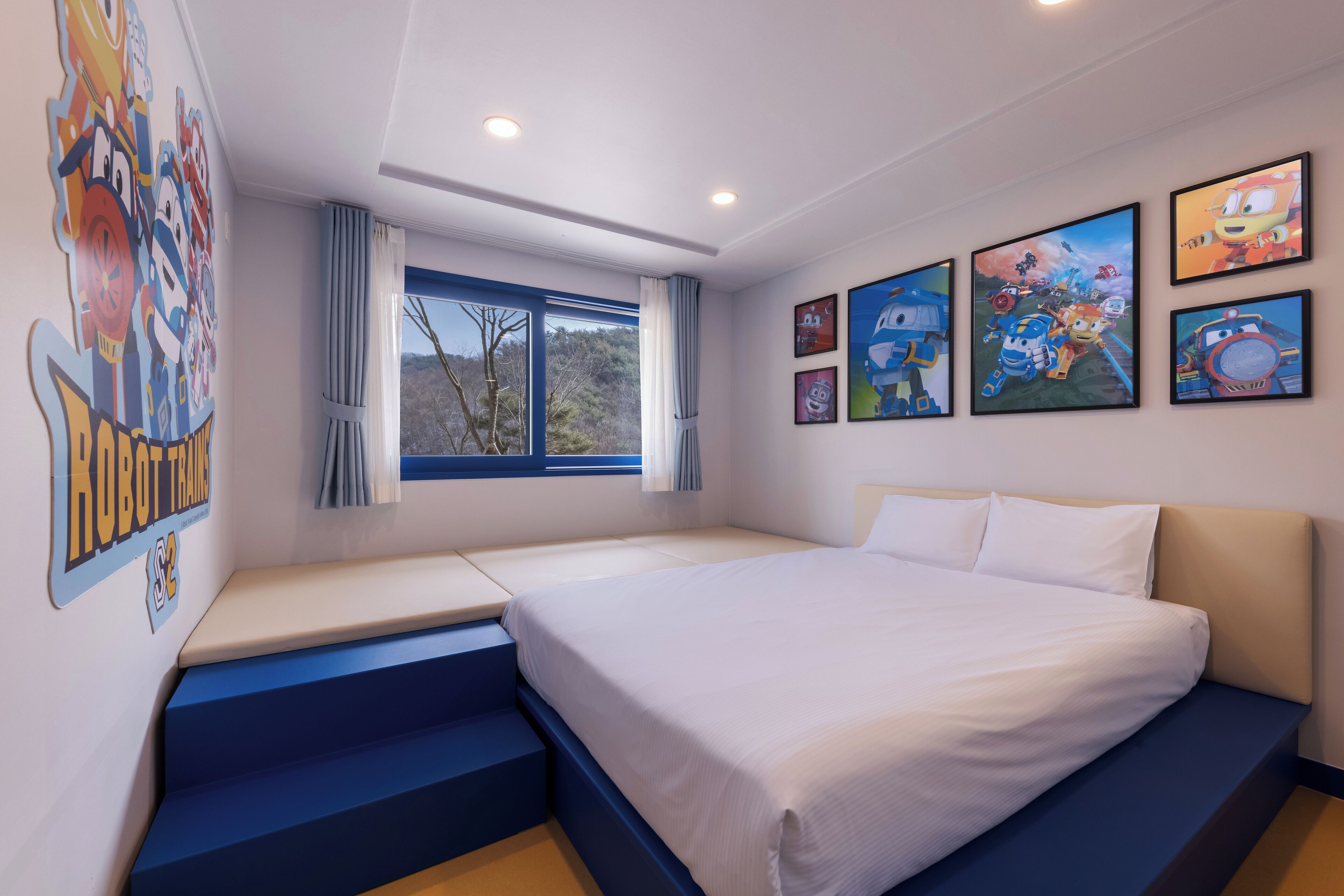 Een slaapkamer met een bed, een raam met gordijnen en wanddecoratie.