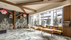 Una sala de estar moderna con un ventanal grande, un sofá colorido y un original patrón hexagonal en el suelo.