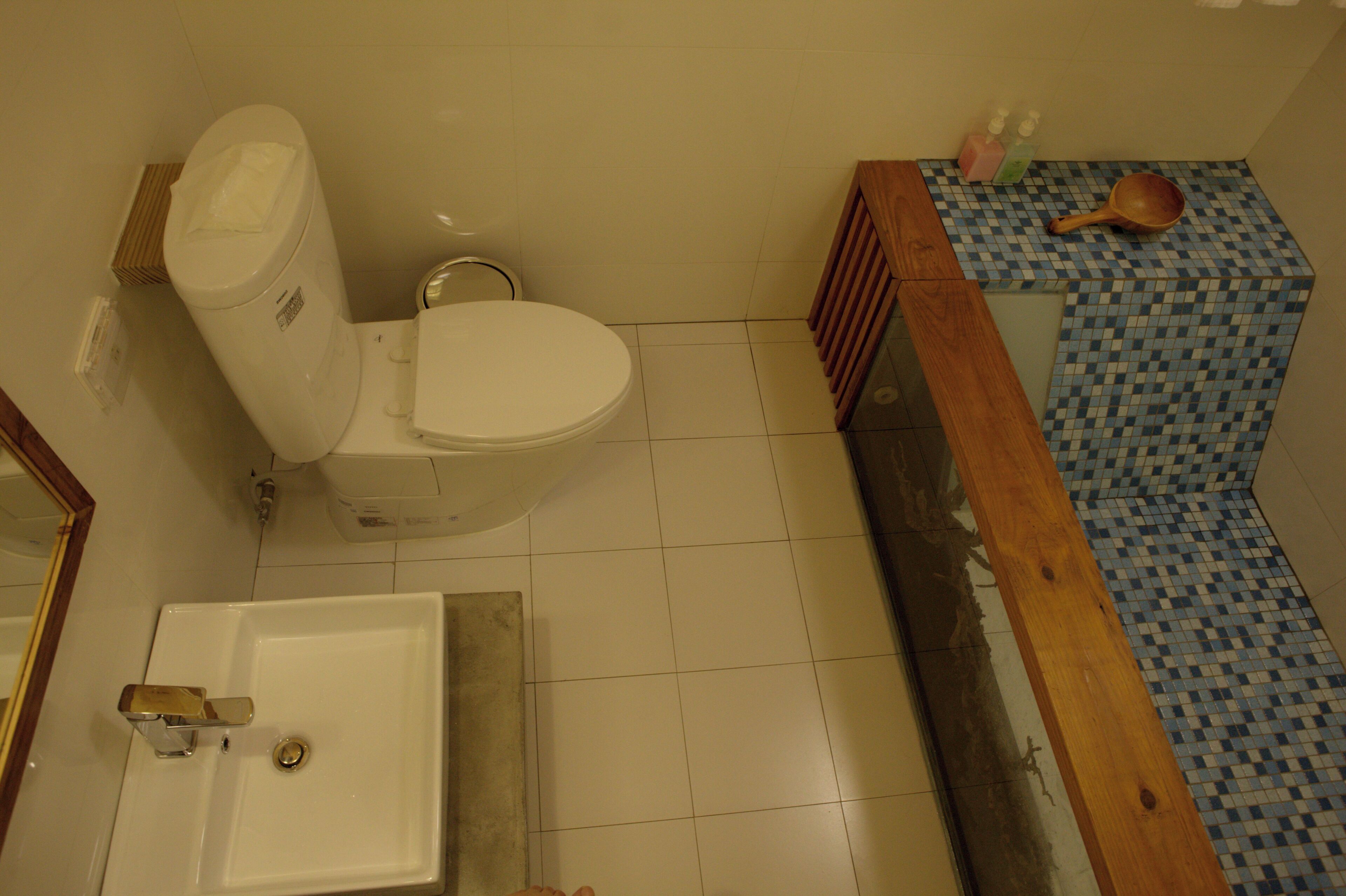 A bathroom with a toilet, sink, and a checkered floor.