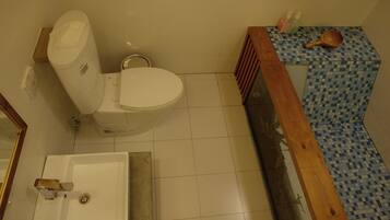 A bathroom with a toilet, sink, and a checkered floor.