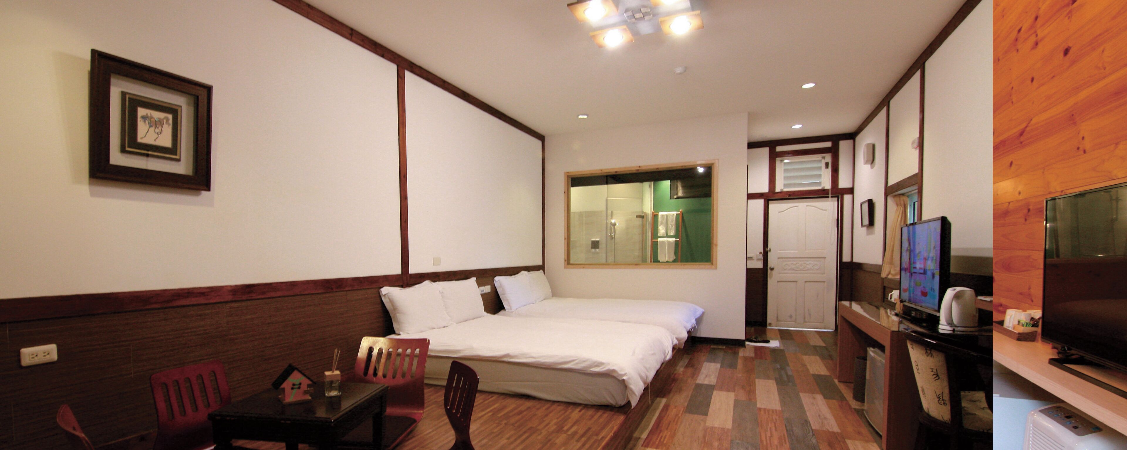 A hotel room with a bed, a desk, a television, and a mirror.