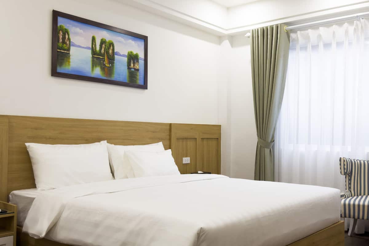 Una cama bien hecha con sábanas blancas en una habitación de hotel.