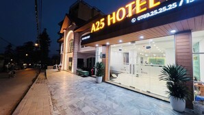 Un hôtel reconnaissable à son enseigne bien visible, à son entrée carrelée et à ses plantes en pot.