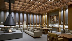 A modern library with a central fireplace, comfortable seating, and bookshelves.