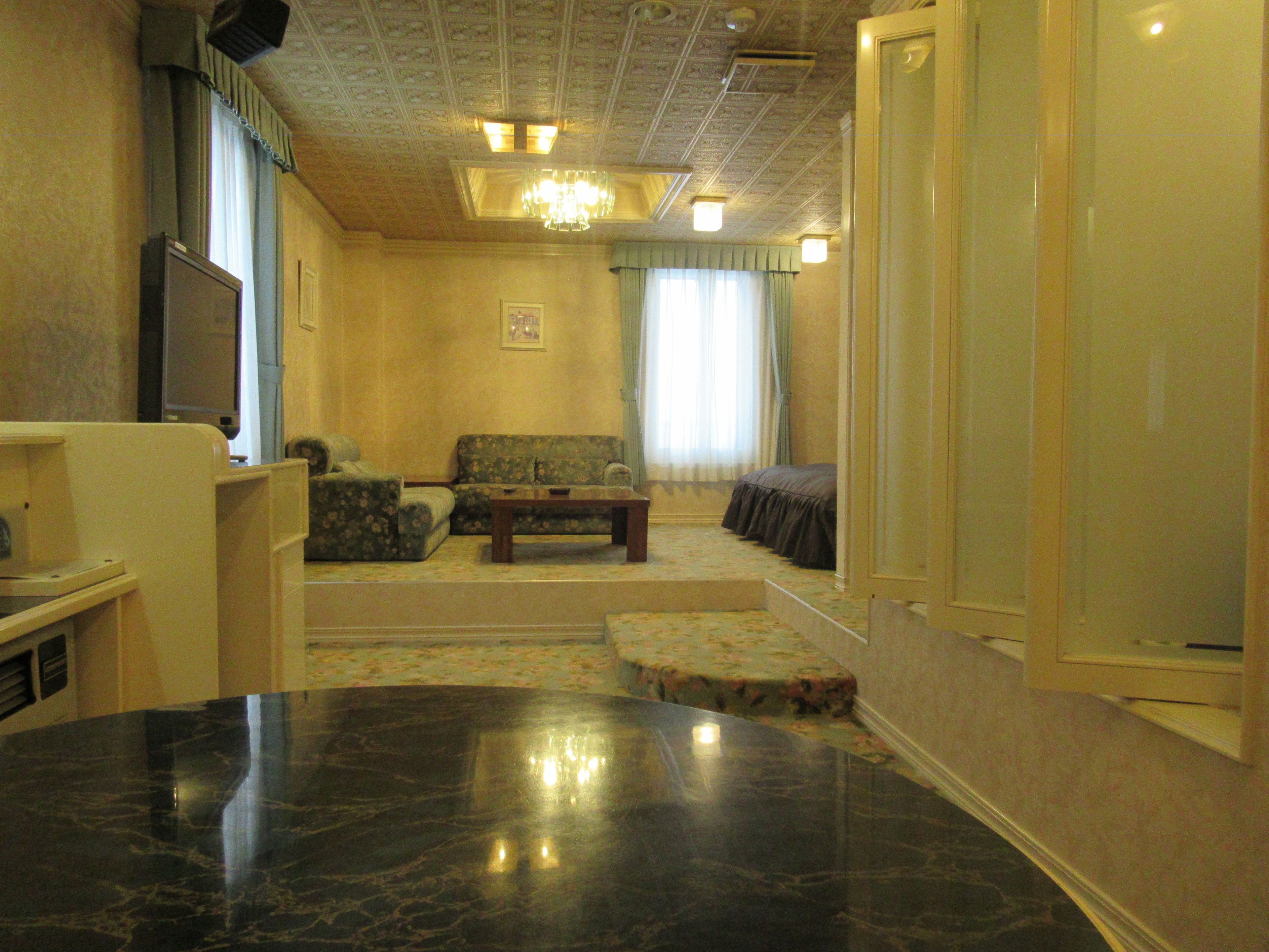 A living room with a sofa, armchair, and a television.