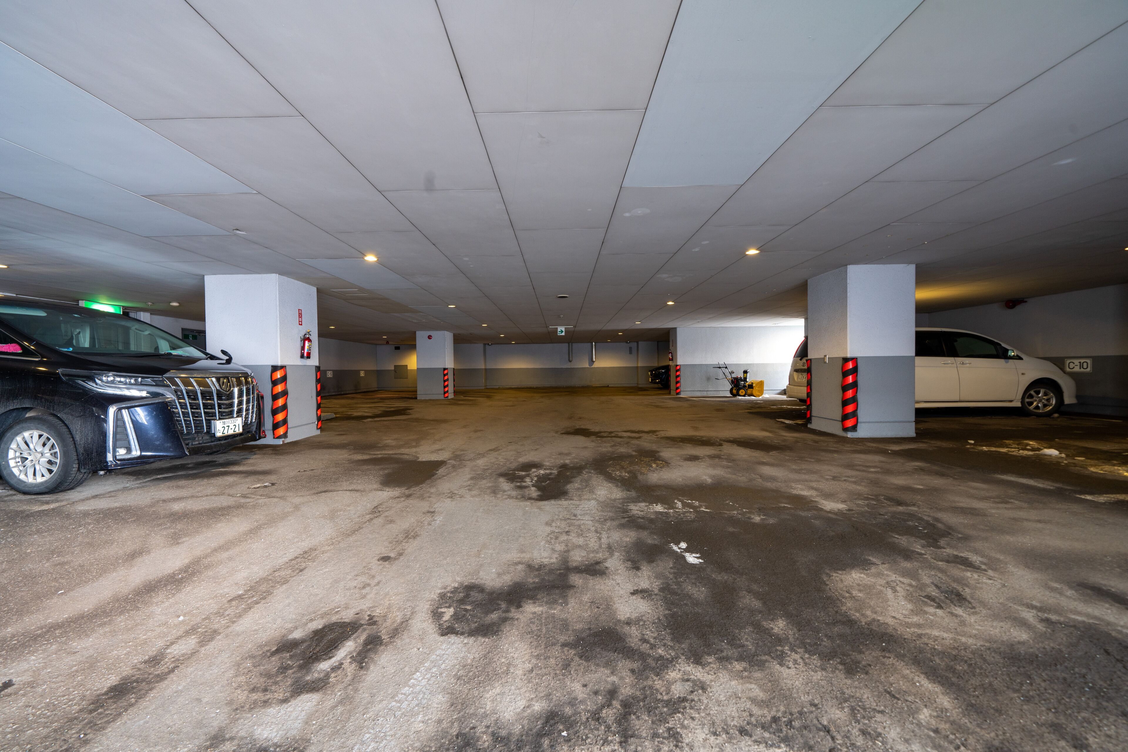 Un parcheggio multipiano con pavimenti in cemento e pilastri bianchi.
