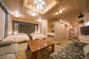 A hotel room with two beds, a wooden table, floral-patterned sofas, a TV, and a mirror. - Hotel Liberte Asahikawa (Asahikawa)