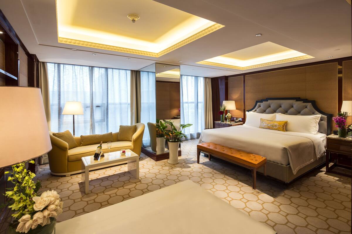 Una habitación de hotel con una cama grande, un sofá, una mesa de centro y un escritorio.