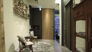 A modern living room with a wooden cabinet, a fluffy rug, and a dining area with a chair and table. - Chez Taipei No5 (Taipei)