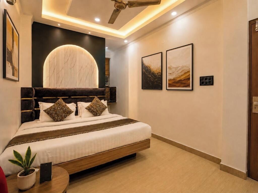 Une chambre moderne avec un lit, un ventilateur de plafond, un luminaire fixé au mur et des œuvres d’art encadrées.