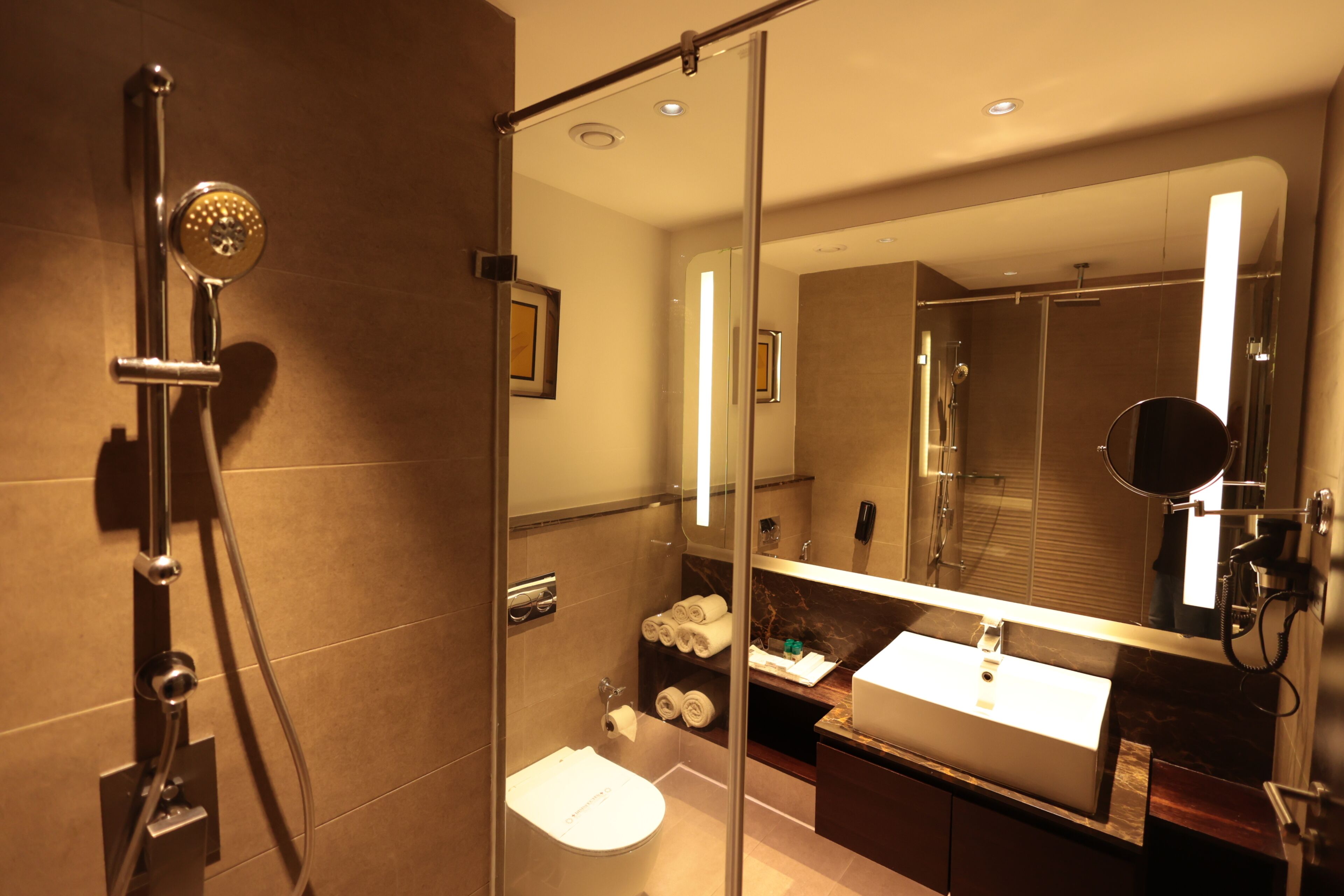Un bany modern amb dutxa de vidre, un lavabo i un mirall.