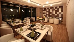 A modern dining area with tables set for service, a checkered wall, and pendant lighting. - Cenneys Gateway - Pride of Salem (Salem)