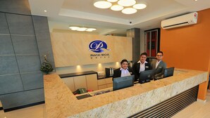 A reception desk at Pantai Regal Hotel with a modern design, a logo, and a digital screen. - Pantai Regal Hotel (Kuantan)