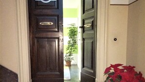 A hotel entrance with a dark wooden door, a sign reading "Mon Light Hotel & Suites", and a doormat with the same name. - Moonlight Hotel & Suites (Catania)