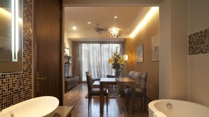 Une salle de bain moderne dotée d’une grande baignoire, d’un lavabo et d’un coin repas avec une table et des chaises.