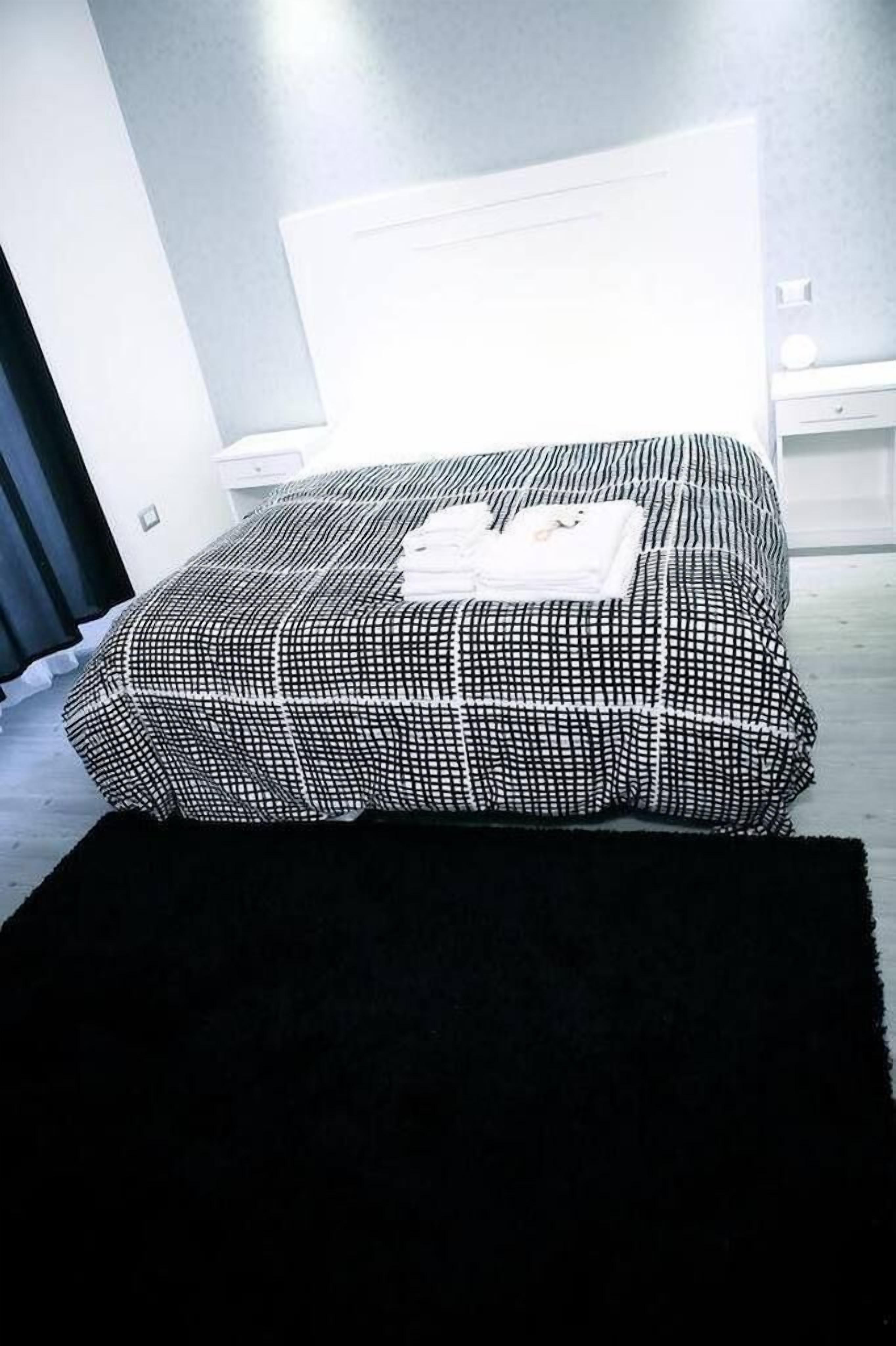 Una camera da letto moderna con un letto grande, un comodino e una abat-jour.