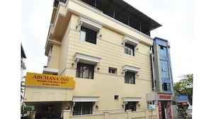 A multi-story building with a sign for 'ARCHANA INN' indicating rooms for daily rent. - Archana Inn (Kanayannur)