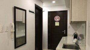 A compact bathroom with a sink, mirror, and toilet. - Umali Kayo at Megatower Residences II (Baguio)