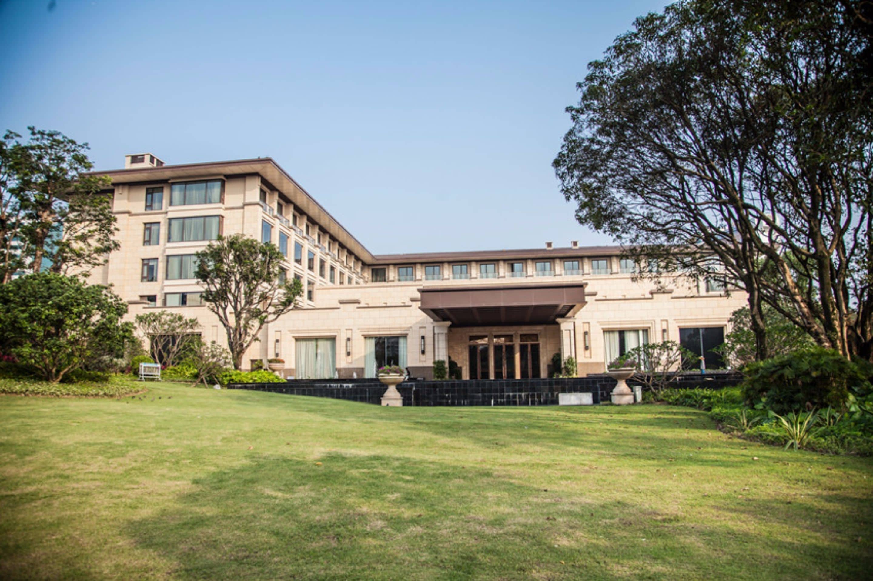 A large, multi-story hotel with a prominent entrance, surrounded by well-maintained lawns and trees.