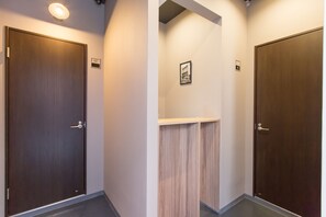 A hallway with two wooden doors, each marked with a number. - Group STAY CLASSE 01 (Osaka)