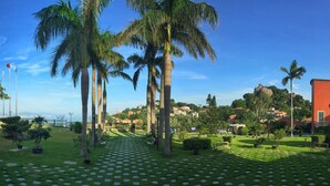 A garden with palm trees, benches, and a pathway. - Marine Garden Hotel (Xiamen)