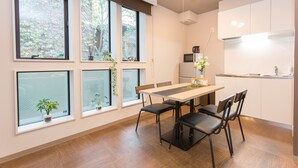 A modern kitchen with a dining area, large windows, and a refrigerator. - Group STAY CLASSE 02 (Osaka)