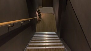 A modern staircase with a wooden finish and a handrail, leading to a lower level. - Group STAY CLASSE 02 (Osaka)