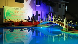 A pool area with a decorative bridge and a large illuminated sign. - Green Hotel Danang (Da Nang)