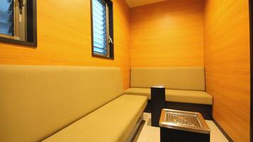A small, enclosed room with wooden walls and a bench.