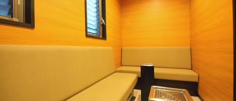 A small, enclosed room with wooden walls and a bench.