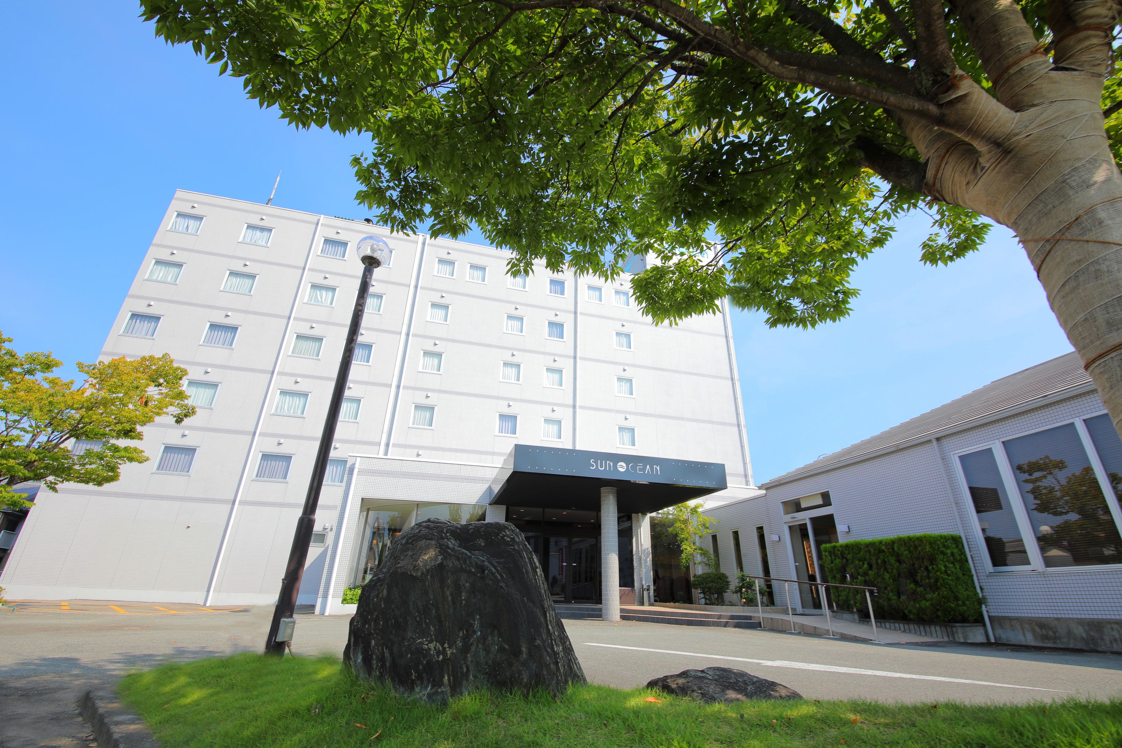Un edificio moderno con fachada plana, varias ventanas y un cartel que dice "SUN OCEAN".