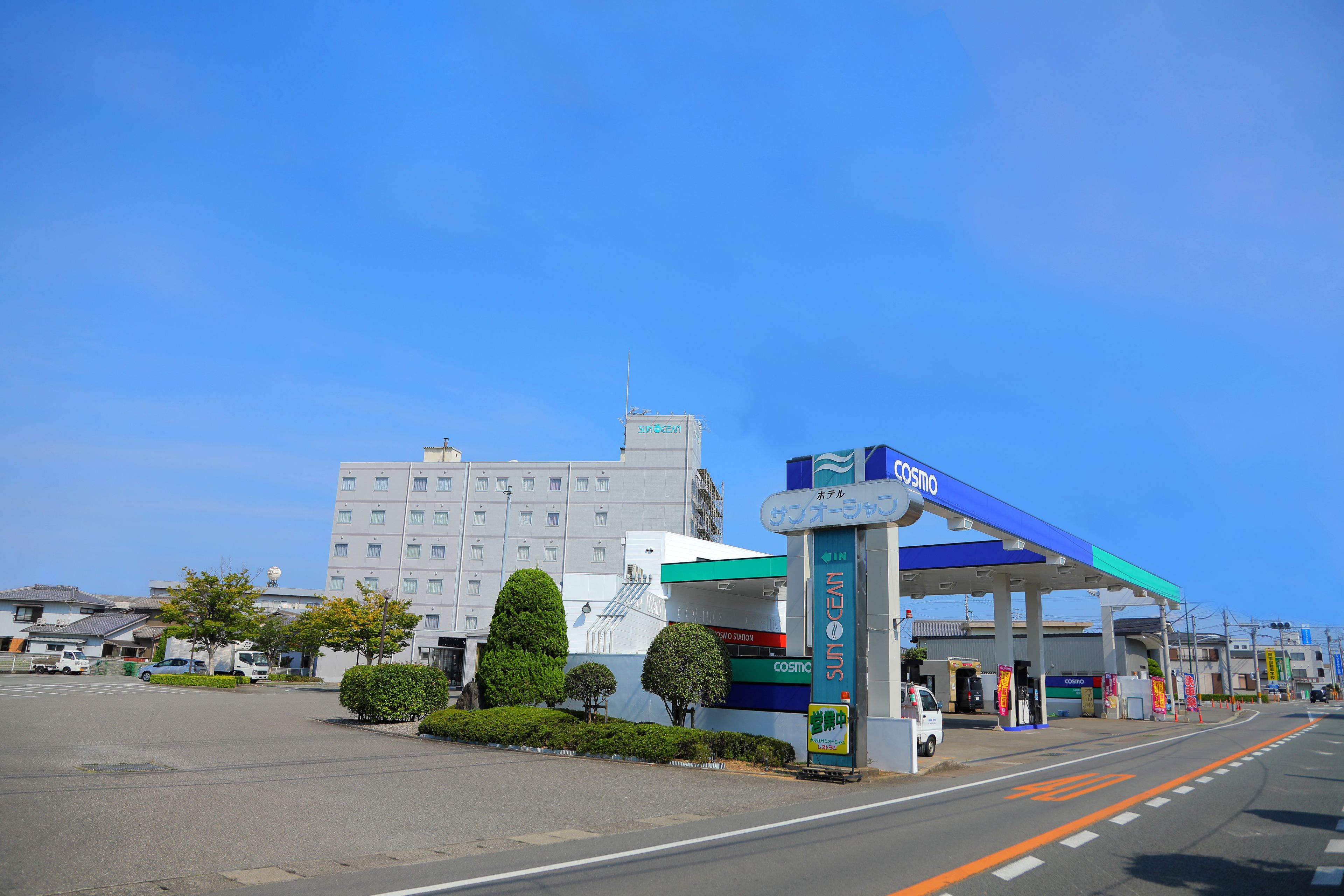A gas station with a blue canopy and a sign that reads "Cosmo".